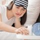 Young lady with water and pill bottle on night stand