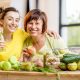 Mother daughter with apples, cucumbers, nuts