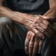 Senior man with wrinkled hands resting on knee